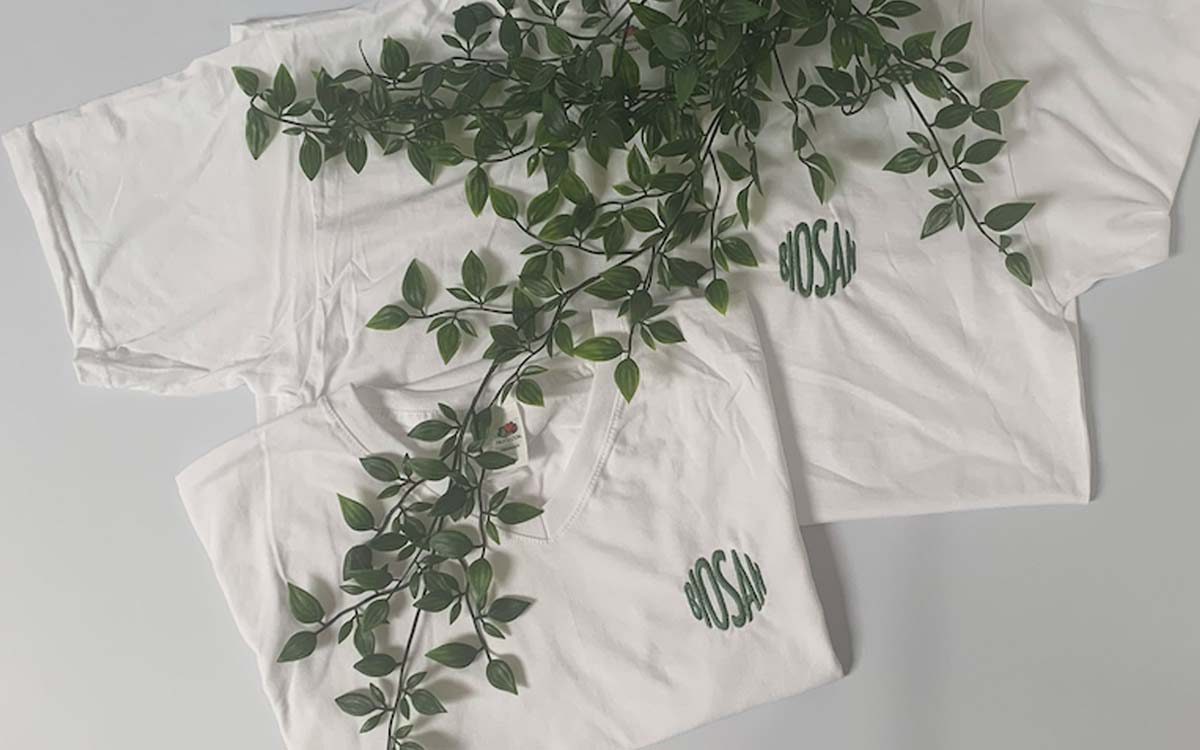 V-Neck T-Shirt in weiß mit Biosan Logo bestickt und mit pflanze dekoriert